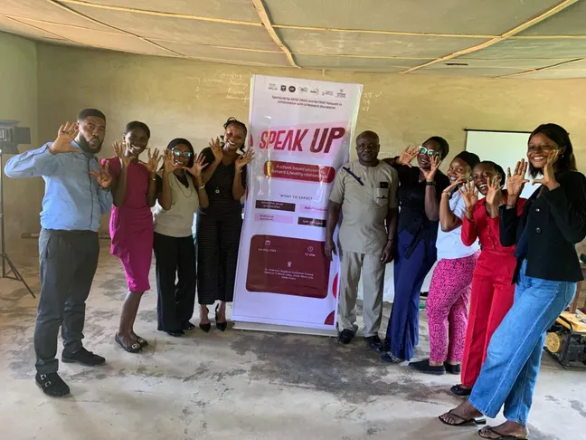 people posing in front of banner